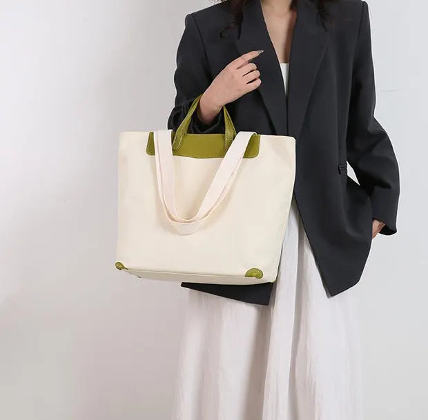 ダブルハンドルキャンバストートバッグを着用する女性